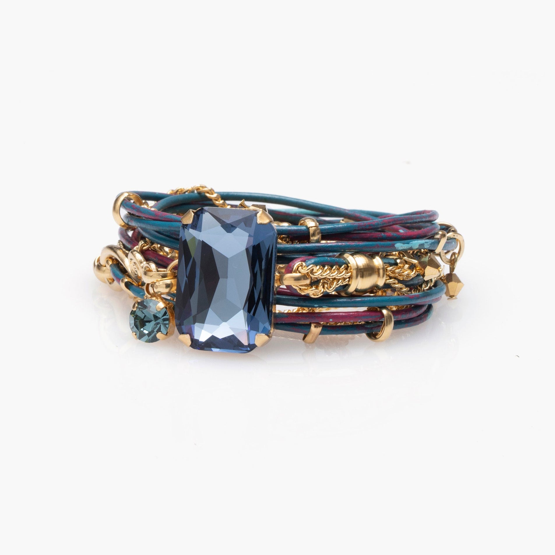 Multistrand bracelet with blue gemstone and gold accents on a white background