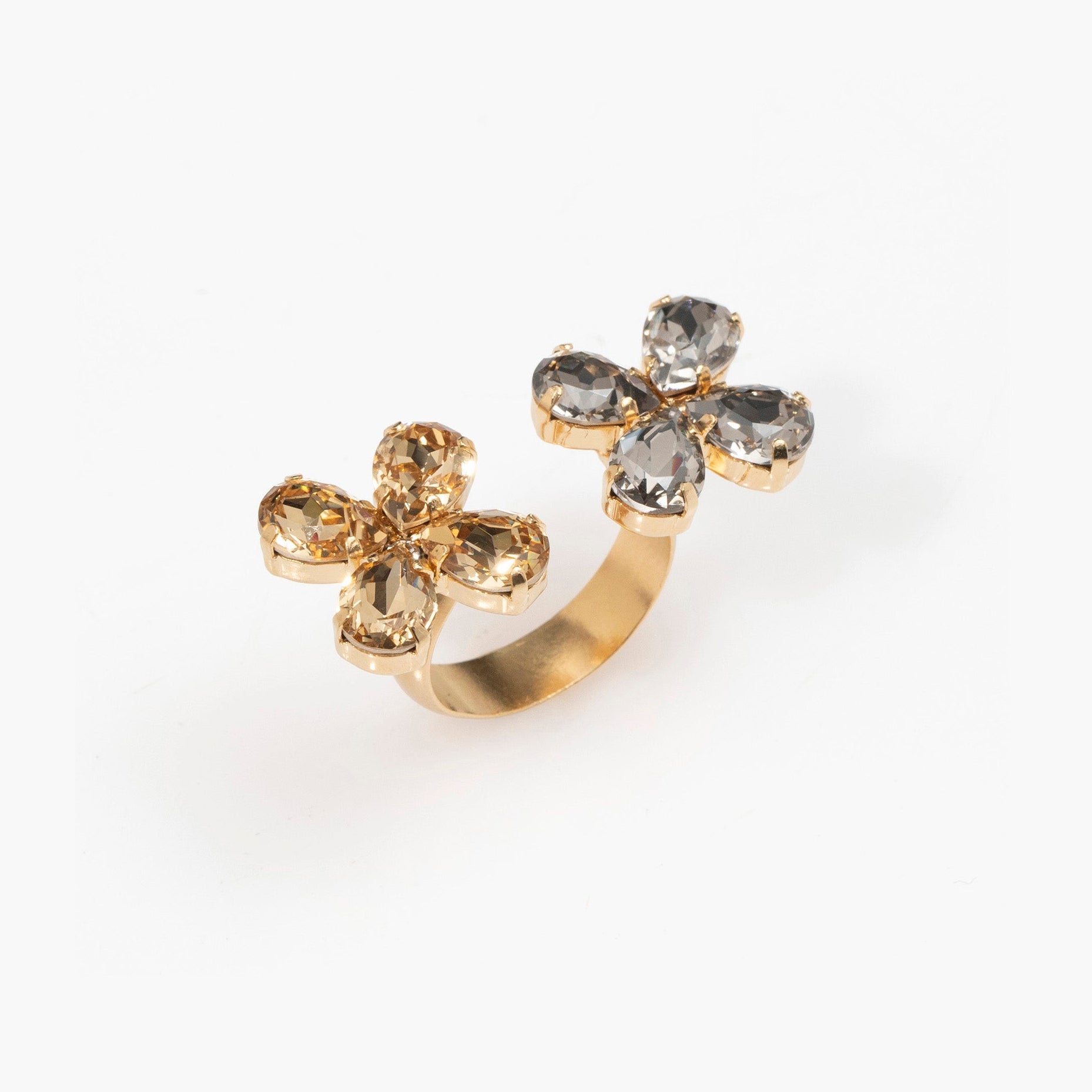Gold ring with floral designs and gemstones on a white background