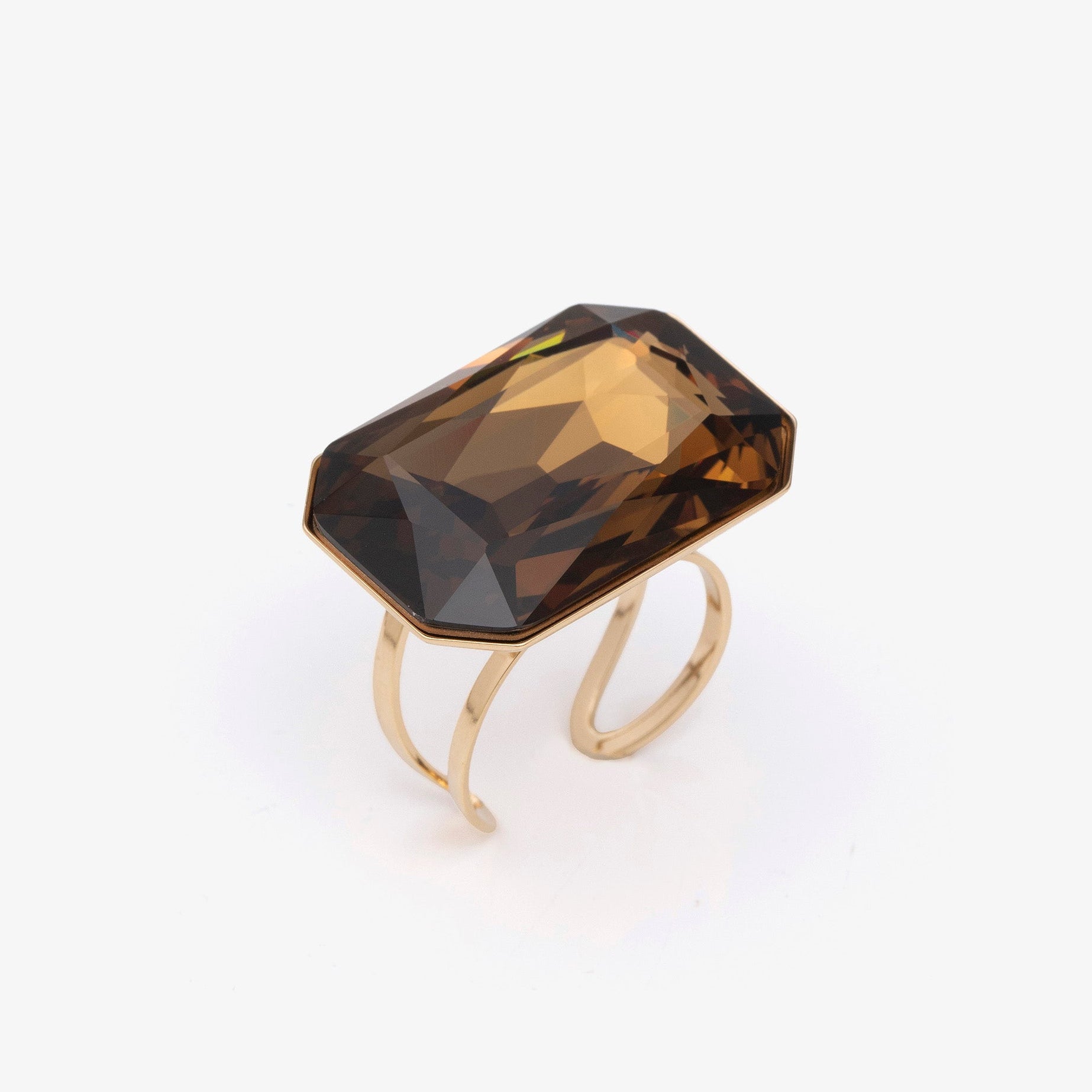 Gold ring with a large brown gemstone on a white background