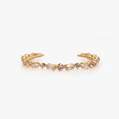 Gold earring with clear gemstones on a white background