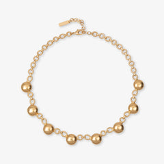 Gold necklace with spherical beads on a white background