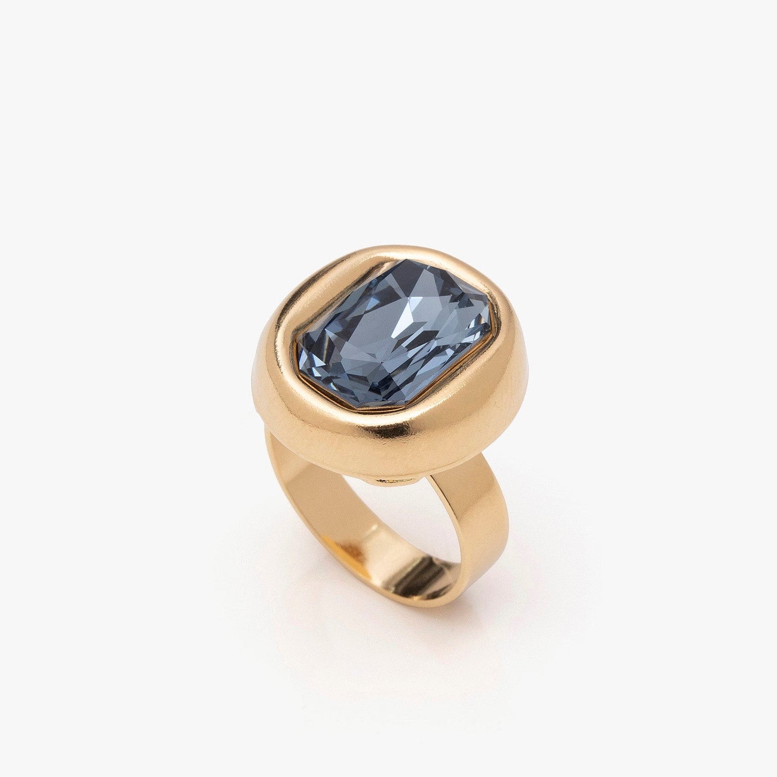 Gold ring with a blue gemstone on a white background