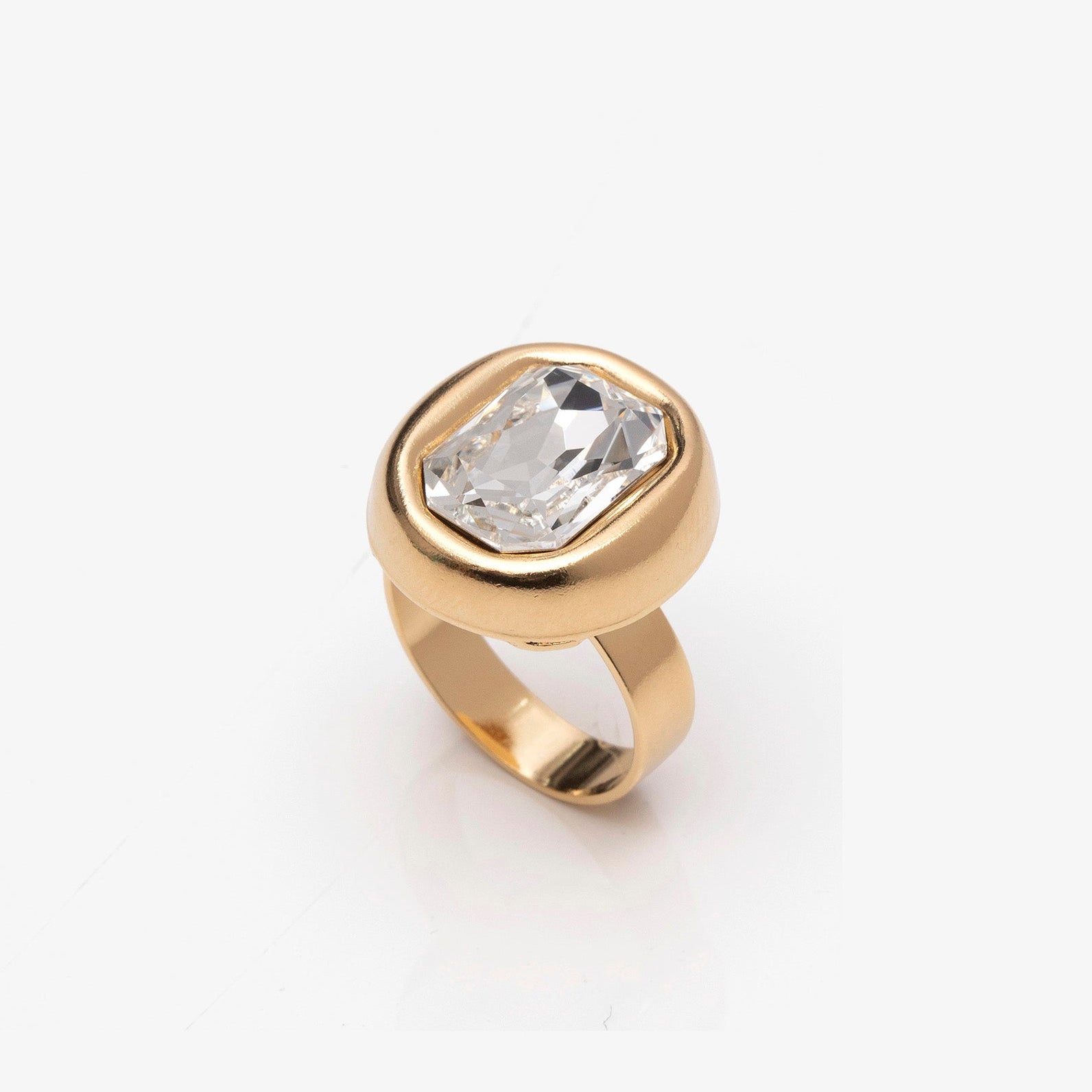 Gold ring with a clear gemstone on a white background