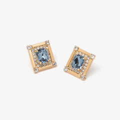 Pair of gold earrings with blue gemstones on a white background