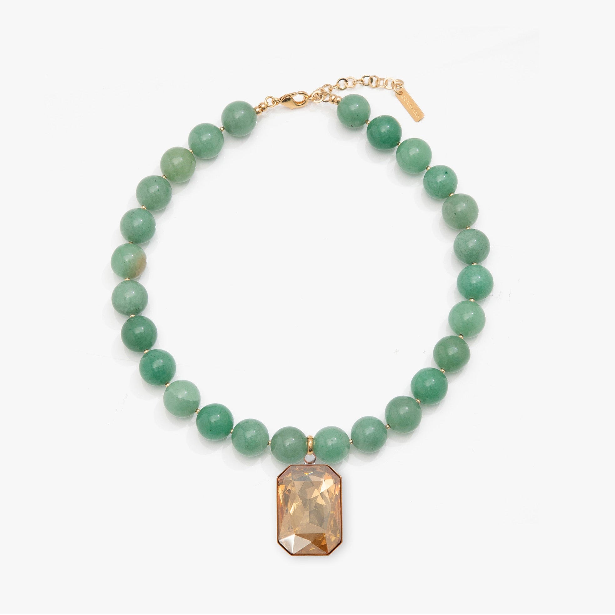 Necklace with green beads and a rectangular brown pendant on a white background