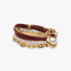 Multistrand bracelet with pearls and gold accents on a white background