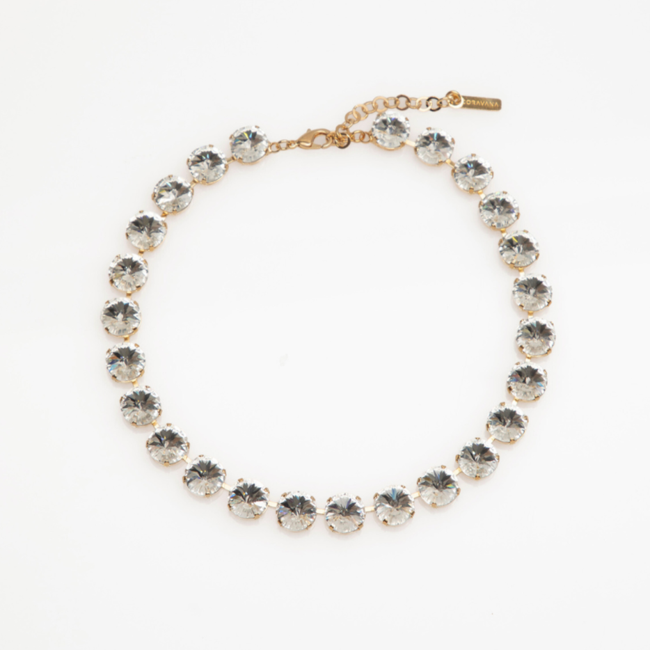 Gold necklace with clear gemstones on a white background