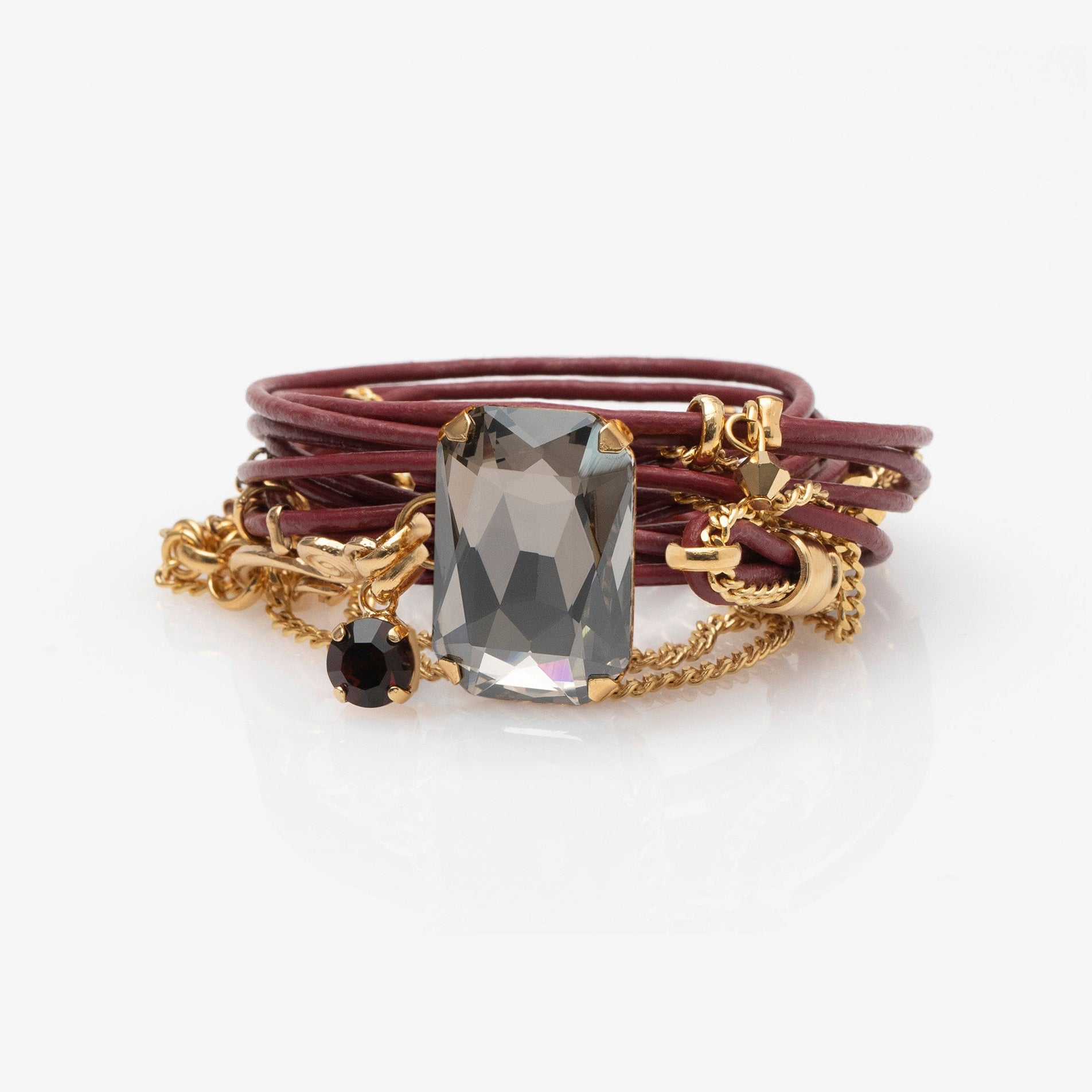 Multistrand bracelet with a central crystal stone on a white background