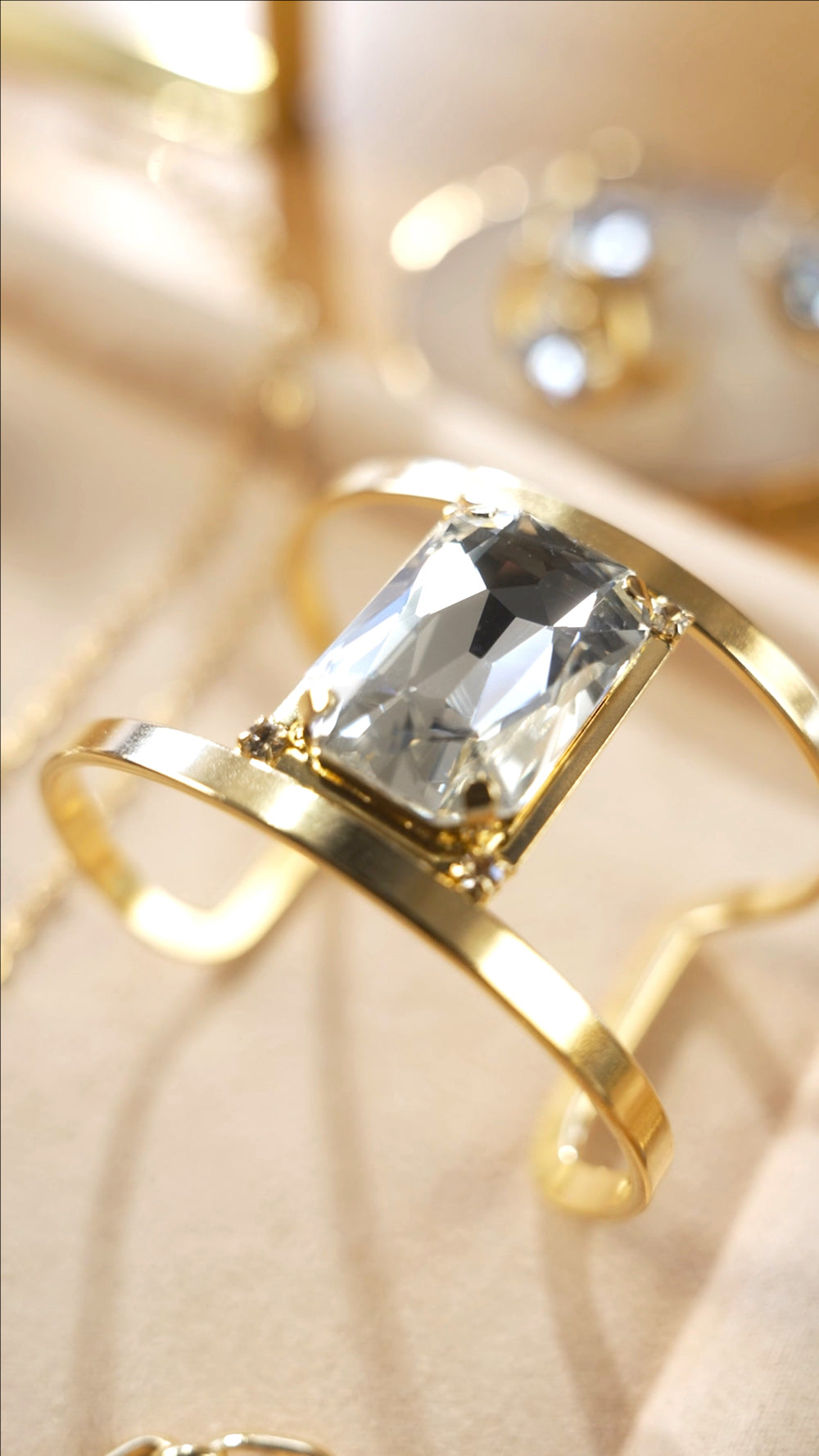 Gold ring with a large diamond on a beige fabric background