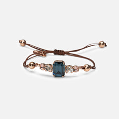 Bracelet with a blue gemstone and rose gold accents on a white background